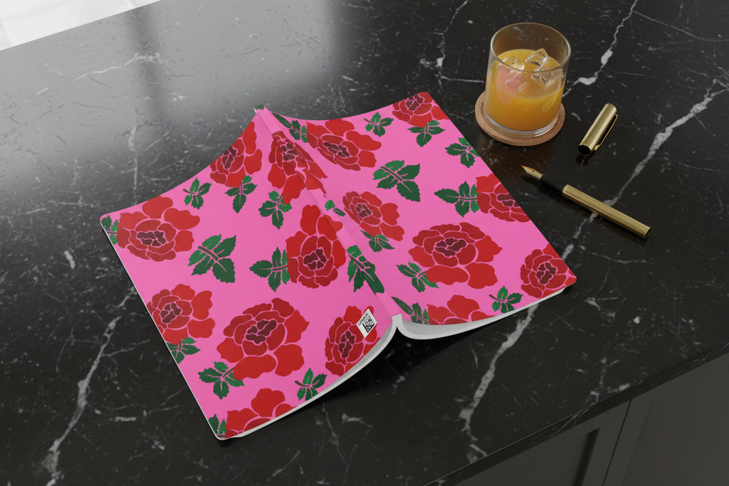 Red roses illustrated softcover journal face down on a table.