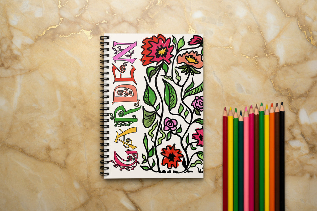 Notebook with colorful floral design and vertical "garden" text on off-white.