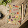 Notebook with 'Garden Plans' cover featuring illustrations of vegetables on a wooden surface.
