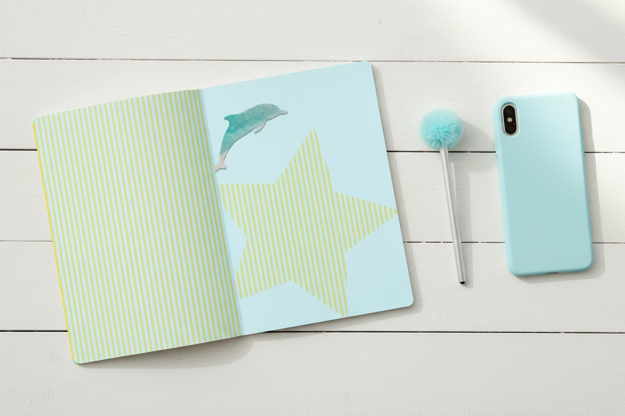 Notebook with a dolphin illustration on a blue and green striped pages.